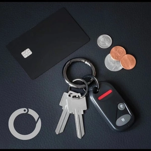Detailed view of gunmetal spring ring clasp with keys on black textured leather
