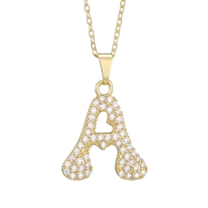Macro shot of gold-plated letter A pendant with sparkling cubic zirconia on a delicate chain