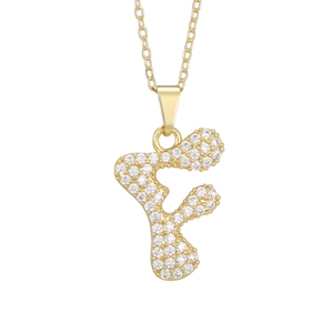 Macro detail of gold letter F pendant necklace paved with sparkling white zircons