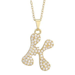 Detailed close-up of golden letter K pendant with sparkling zircon micro-pave setting