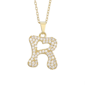 Macro shot of gold-plated letter R pendant necklace with pavé cubic zirconia inlay