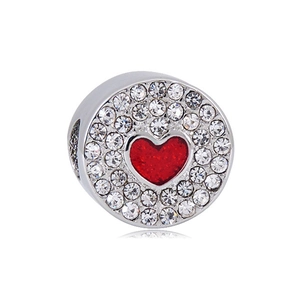Detailed macro view of silver bead charm with red enamel heart and clear zircon pavé