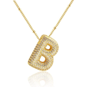 Dettaglio del ciondolo a lettera B dorata a bolla con zirconi micro-pave e catena fine