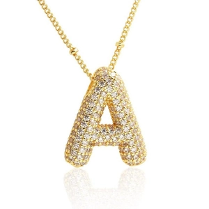 Collana dorata con pendente lettera A pavé di zirconi cubici su sfondo bianco pulito
