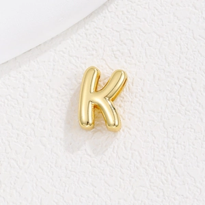 Détail macro du pendentif lettre K style bulle 3D avec placage en or 18 carats brillant