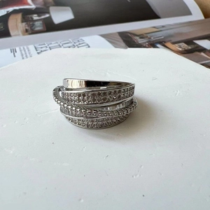 Dettaglio anello incrociato multistrato in argento con micro-pavé di zirconi cubici
