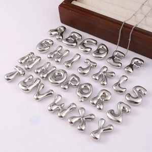 Silver 26 initial letters pendant set with chubby 3D design on a wooden jewelry display