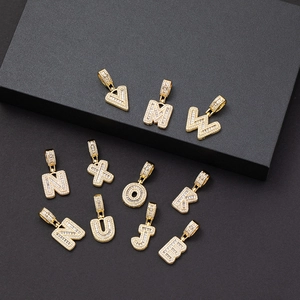 Goldene Iced Out Hip-Hop Buchstabenanhänger mit Zirkonia auf schwarzem Display-Hintergrund