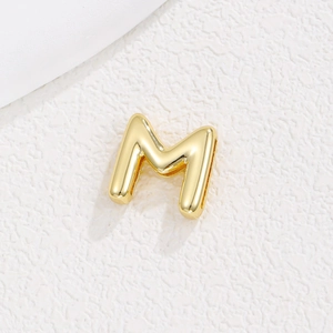 Vue détaillée du pendentif lettre M plaqué or poli avec finition miroir brillant