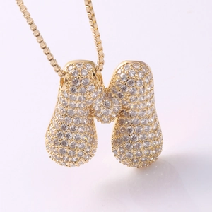 Macro shot of gold-plated letter M pendant with cubic zirconia micro-pave setting