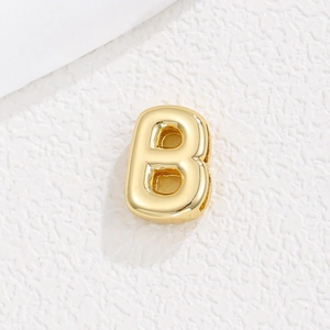 Makro-Detail eines 3D-vergoldeten Buchstaben-B-Anhängers mit Hochglanzpolur