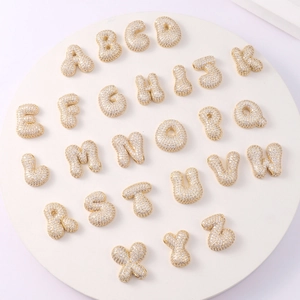 Macro view of gold-plated bubble letters A-Z featuring sparkling pave-set cubic zirconia
