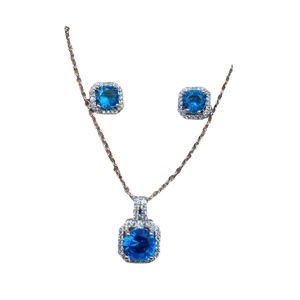 Elegant halo jewelry set featuring a deep blue stone necklace and matching stud earrings