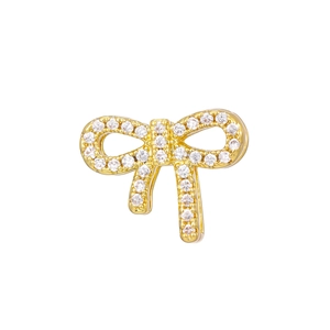 Close-up of golden bow-shaped jewelry charm with micro-paved cubic zirconia stones