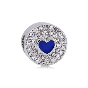 Detailed macro view of heart-shaped silver charm bead with blue enamel and crystal inlay