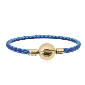 Detalle de pulsera de cuero trenzado azul con cierre de bola de metal dorado brillante