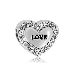 Macro view of heart-shaped charm with LOVE engraving and pave-set cubic zirconia stones
