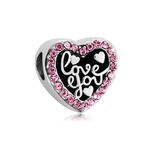 Macro shot of heart-shaped charm with black enamel 'Love you' script and pink crystals