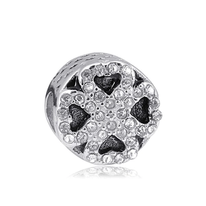 Detail of silver clover charm with sparkling zircon pave and hollow heart pattern