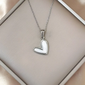 Elegante collar de acero inoxidable con colgante corazón de nácar blanco sobre seda champán