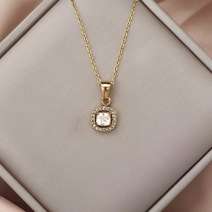 Dettaglio del ciondolo in zircone quadrato su collana dorata in una scatola per gioielli