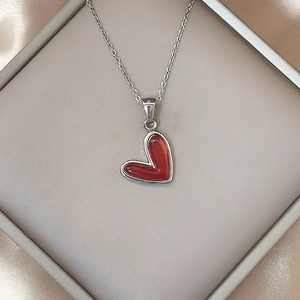 Detalle del colgante de corazón esmaltado rojo en cadena de acero inoxidable plata