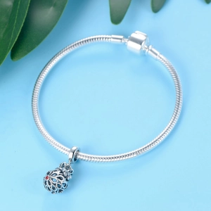 925 silver snake chain bracelet with hollow charm and red gemstone on a blue background