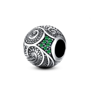 Dettaglio di charm in argento S925 con pietre verdi e incisioni a spirale vintage