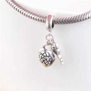 Macro shot of S925 sterling silver heart locket pendant with rose relief and key charm