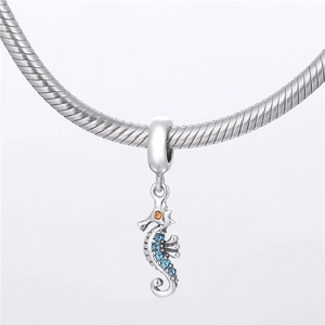 Vue macro du pendentif hippocampe en argent avec cristaux bleus sur un bracelet serpent