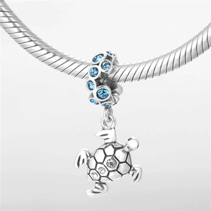 Détail du pendentif tortue en argent S925 avec cristaux bleus sur un bracelet serpent