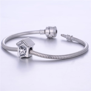 Macro detail of S925 sterling silver cat house charm with pavé crystals on a snake chain