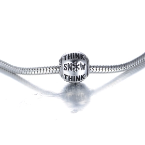 Macro-opname van S925 zilveren sneeuwvlokbedel met Think Snow gravure op een ketting