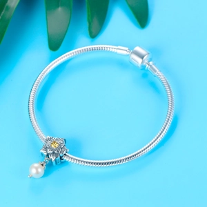 S925 silver bracelet with floral pearl pendant and yellow gemstone on blue background
