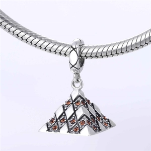 Vue macro d'un pendentif pyramide en argent S925 avec zircons orange sur chaîne serpent