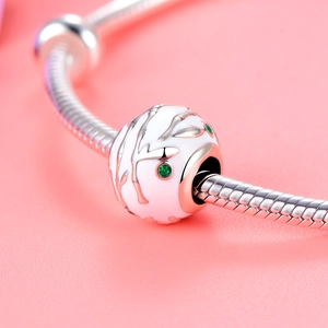 Macro-opname van 925 zilveren kraal met wit emaille en groene stenen op een slangenketting