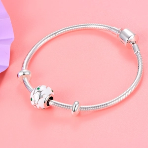 Macro-opname van 925 zilveren slangenarmband met witte emaille bloembedel en groene details