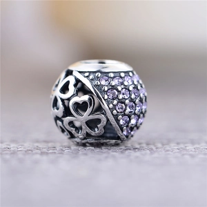 Vista macro de charm en plata S925 con corazones calados y cristales violetas pavé