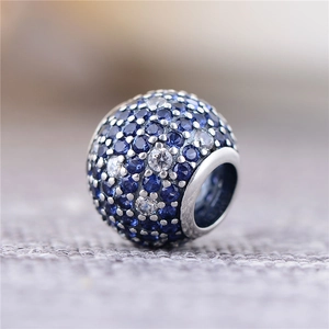 Detalle de un charm de plata S925 con pavé de piedras azules y transparentes