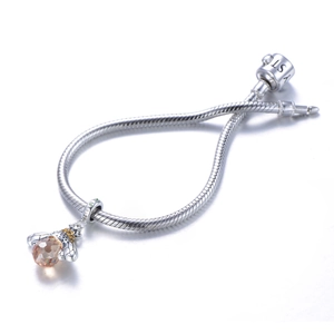 Détail macro du pendentif abeille en argent S925 avec ambre sur bracelet à chaîne serpent