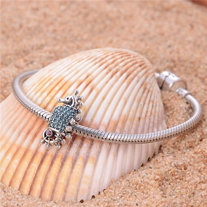 Detailed shot of S925 silver seahorse charm with blue zircons on a snake chain bracelet