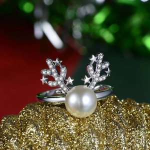 Nahaufnahme von S925 Silber Rentierhorn Ring mit Perle und Sternen auf festlichem Goldgrund