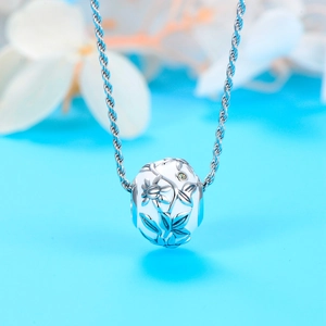 Close-up van 925 zilveren emaille bloem bedel met groene edelsteen aan een getwiste ketting