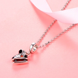 Vue macro d'un pendentif patin à glace en argent 925 avec gemme étoile orange et émail