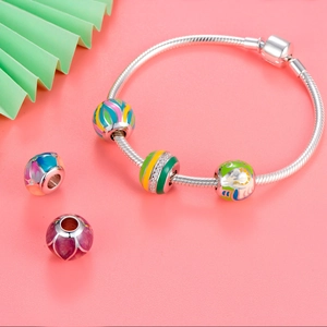 Detalle de pulsera de plata 925 con dijes de cuentas de esmalte de colores vivos