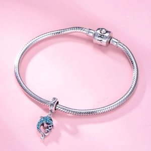 Bracelet chaîne serpent en argent avec charm dauphin en zircon bleu sur fond rose