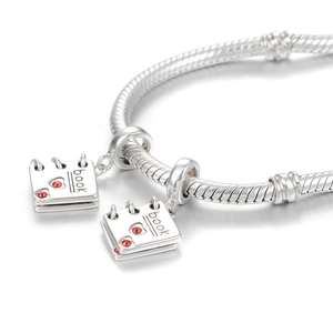 Macro-opname van 925 sterling zilveren boekbedeltjes met rode hartkristallen op armband