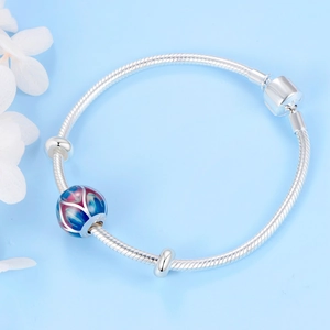 Detalle de pulsera de plata S925 con abalorio de esmalte en degradado azul y lila