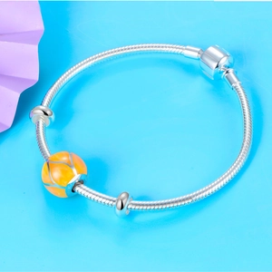 Detalle de pulsera de cadena de serpiente de plata con amuleto esmaltado naranja vivo