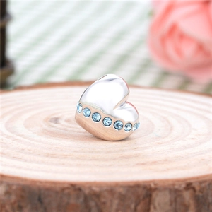 Macro detail van S925 sterling zilveren hartbedel met blauwe kristallen op hout
